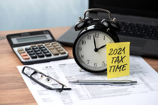 2021 稅務時間註釋在鬧鐘上。稅務和商業概念 - 1040 稅表 圖片 個照片及圖片檔