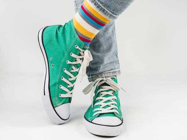 istock Green sneakers and funny socks on a white background 1300180849