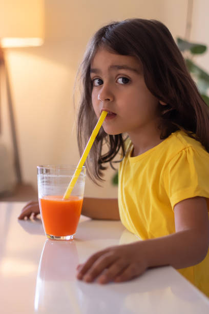 istock little girl drinks juice 1300181593