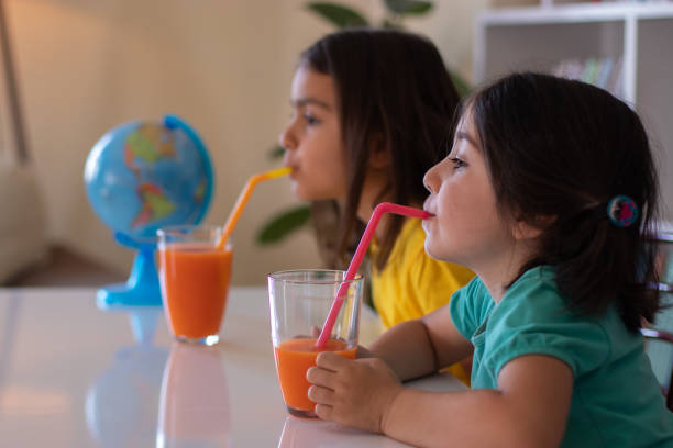 istock little girls drink juice 1300181597
