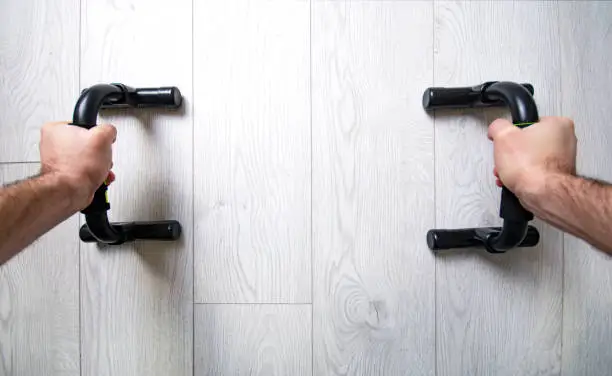 Home workout with push up bars. First-person view.
