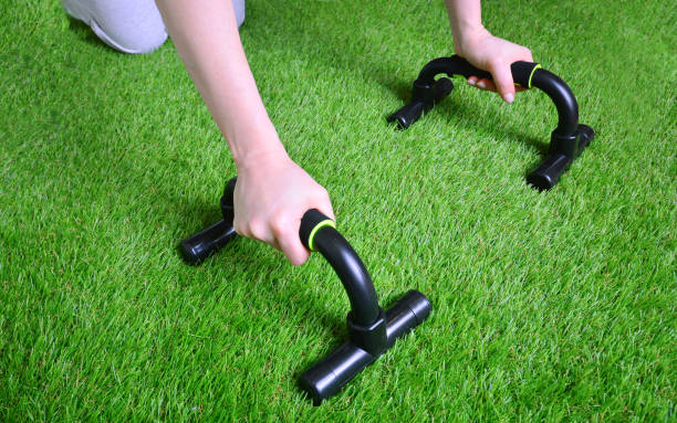Fitness training with push up bars on the artificial grass Fitness training with push up bars on the artificial grass gymnastics bar photos stock pictures, royalty-free photos & images