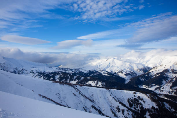 istock Snow peaks of mountains with blue sky and beautiful clouds. 1300189078