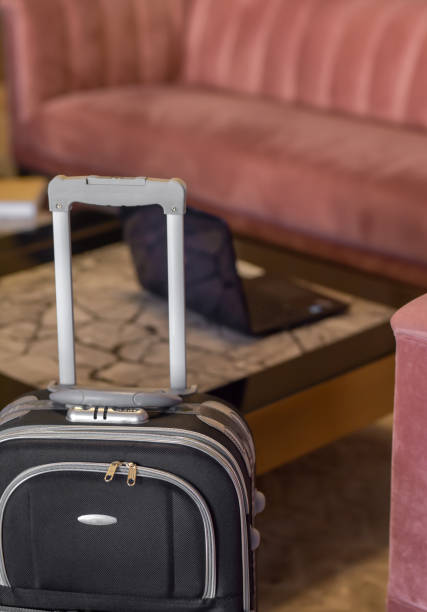 istock Wheeled suitcase and laptop at the hotel lobby 1300190579