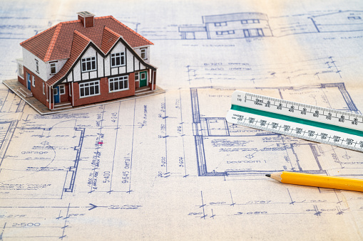 House construction plans with scale ruler and pencil