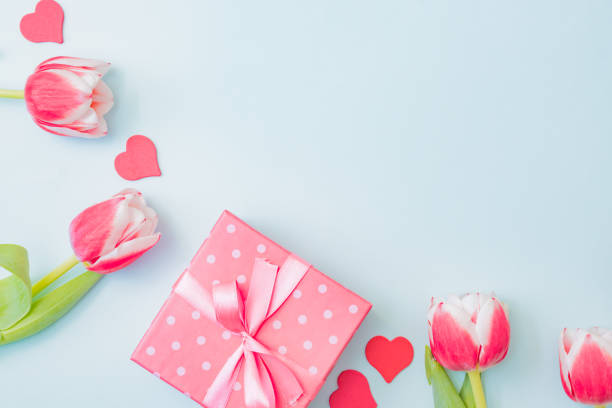 istock Flat lay valentines day frame with pink tulips and gift box on a light green background 1300195431