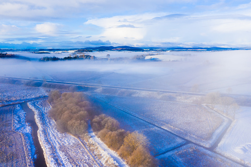 The view from a drone of a rural scene in Dumfries and Galloway south west Scotland there is still an early morning misty after a fresh fall of snow