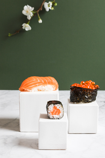Eating Artisanal Sushi Maki Nigiri presented on elegant blocks