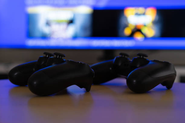 istock Gamepads placed on a coffee table in front of the television. 1300198604