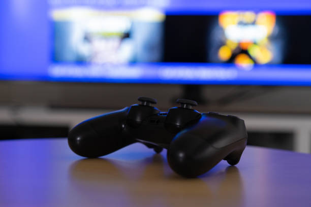 istock Gamepad placed on a coffee table in front of the television. 1300198610