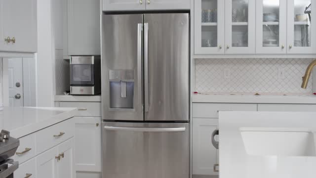 Refrigerator in clean white modern kitchen. Home appliance beauty shot dolly