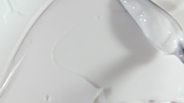 Motion of the Liquid cream, white cosmetic texture with rotation. Contouring, Make up smears background. Organic cosmetics, medicine. Top view. 4K UHD video
