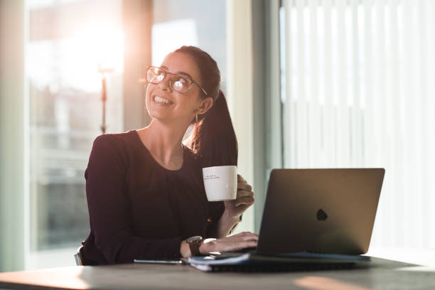 istock Businesswoman drinking coffee and working in modern office. 1300204484