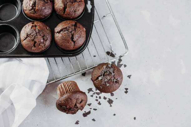 istock Homemade chocolate muffins or muffins, garnished with chocolate chips, on a light table, overlooking. Place for text. Homemade or bakery pastries for breakfast or celebration 1300205289
