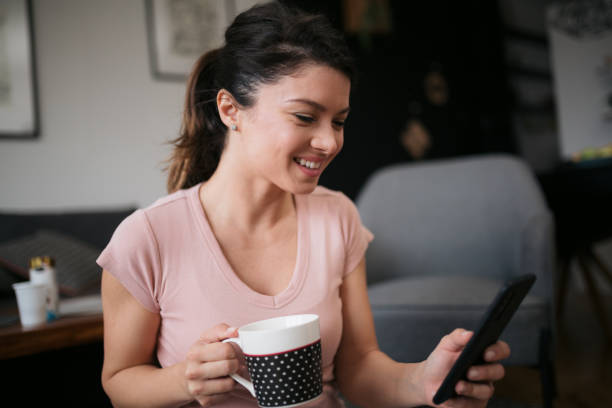 istock Young Caucasian woman planning her day using a smart phone 1300207045