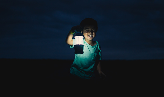 Kid with Lantern at Muriwai Beach, Auckland, New Zealand.