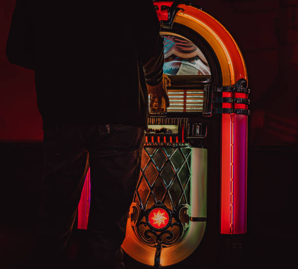 Male hand pushing buttons to play song on old Jukebox, selecting records Male hand pushing buttons to play song on old Jukebox, selecting records digital jukebox stock pictures, royalty-free photos & images