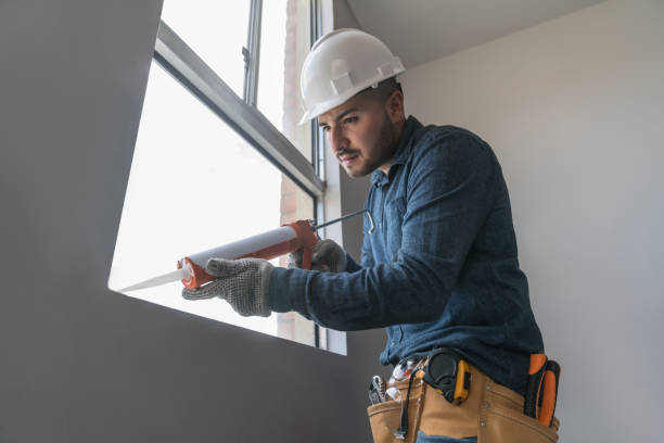 Building contractor installing a window and applying silicone sealant Latin American building contractor installing a window and applying silicone sealant - housing development sealant photos stock pictures, royalty-free photos & images