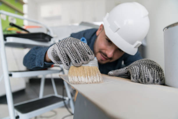 Contractor working on a house project painting a piece of wood Latin American contractor working on a house project painting a piece of wood house painting service stock pictures, royalty-free photos & images