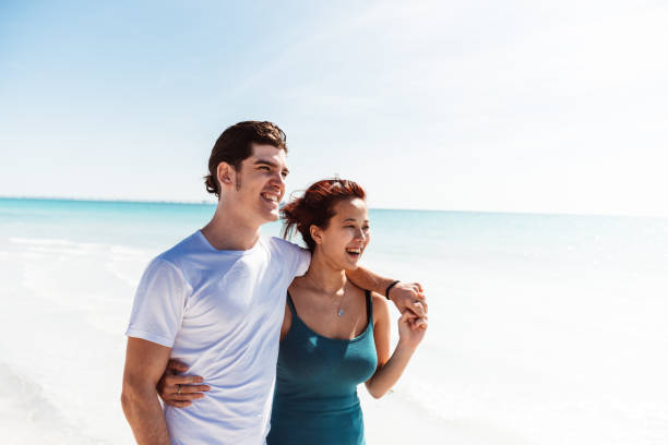 istock couple walking together at the beach 1300212993