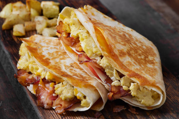 istock The Folded Breakfast Tortilla with Scrambled Eggs, Bacon, Tomato and Cheese 1300213972