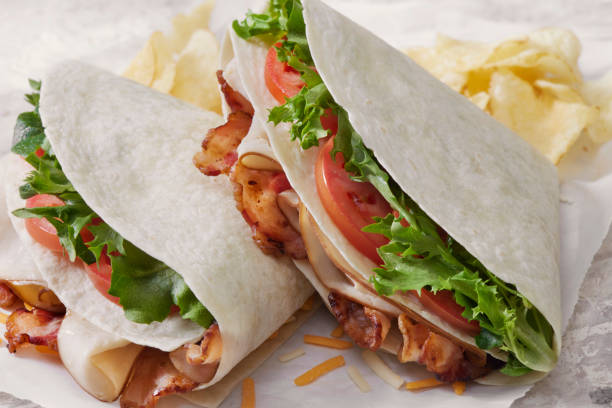 o wrap de tortilla dobrado com, frango rosted, bacon, alface, tomate e queijo - portion turkey sandwich close up - fotografias e filmes do acervo