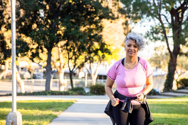 istock Senior black woman with wearable tech jogging 1300214712