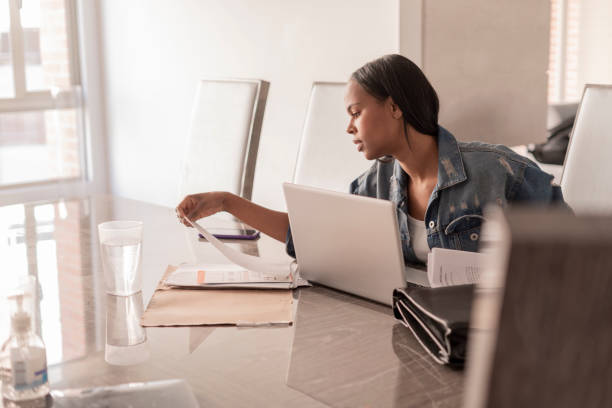 istock Afro woman sitting in her dining room working on a video call 1300215867