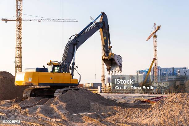 Group Tower Cranes And Excavator Silhouette At Construction Site Sunset Sky Background Stock Photo - Download Image Now