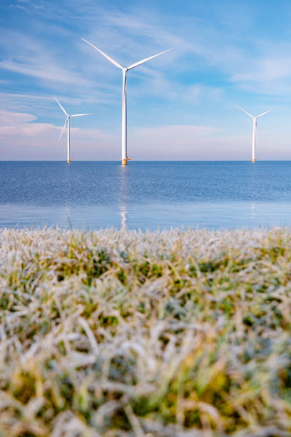 offshore windmill park with stormy clouds and a blue sky, windmill park in the ocean. Netherlands . Europe, windmill turbines in ocean with blue sky, green energy concept