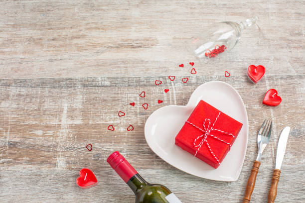 istock Red wine bottle and love gift box, candles, flowers 1300216908