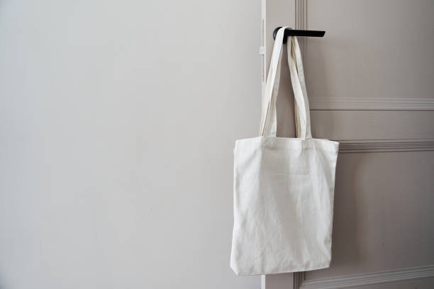 istock White eco friendly bag hanging on the door handle. Canvas tote bag 1300219562