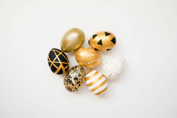 istock Easter golden decorated eggs isolated on white background. Minimal easter concept. Happy Easter card with copy space for text. Top view, flatlay 1300221451