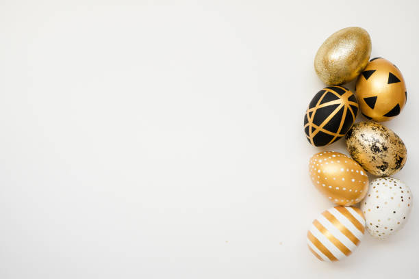 istock Easter golden decorated eggs isolated on white background. Minimal easter concept. Happy Easter card with copy space for text. Top view, flatlay 1300221474