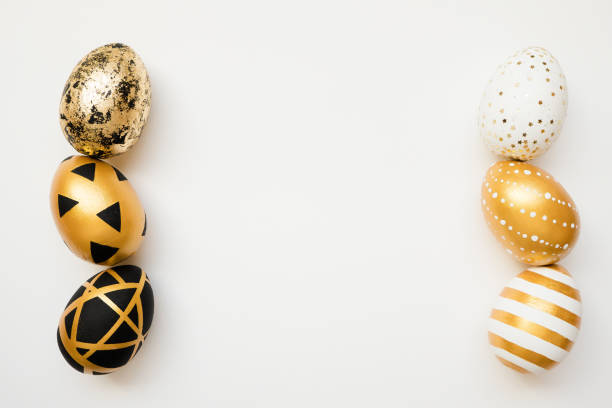 istock Easter golden decorated eggs isolated on white background. Minimal easter concept. Happy Easter card with copy space for text. Top view, flatlay 1300221503