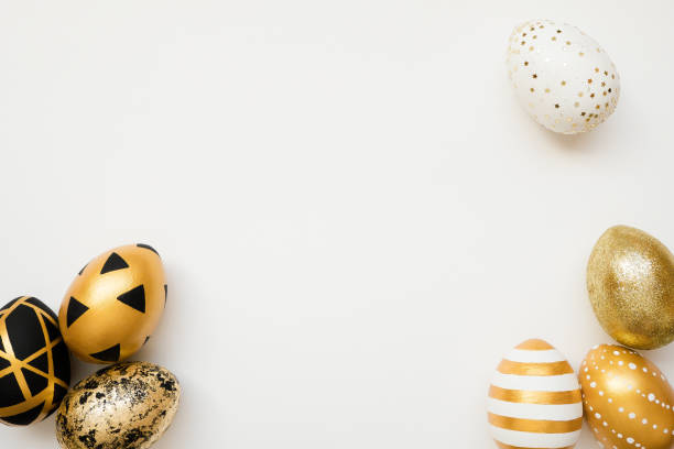 istock Easter golden decorated eggs isolated on white background. Minimal easter concept. Happy Easter card with copy space for text. Top view, flatlay 1300222097