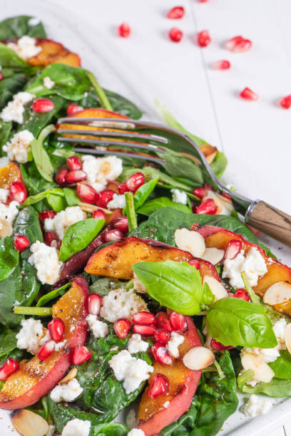 istock Salad. Spring vegetable salad. Fresh vegetable salad with grilled peach, pomegranate, spinach and fresh cheese. 1300223123