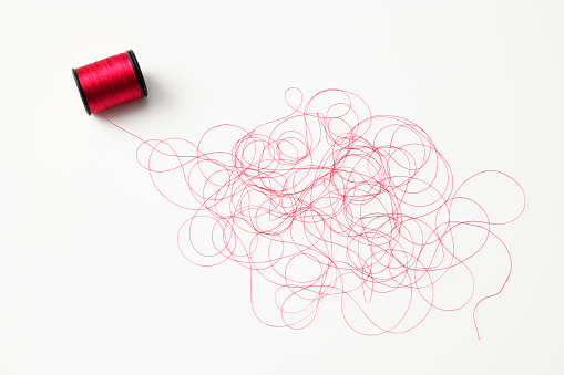Crowded red thread with spool, isolated on white.