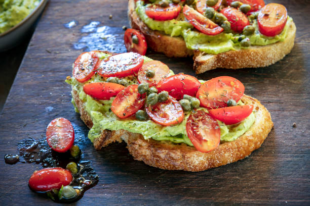 istock Avocado toast with tomatoes, capers and dill.  Sourdough bread.  On chopping board. 1300227534
