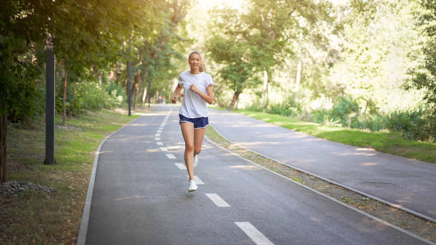 istock Woman running asphalt road summer park 1300227676