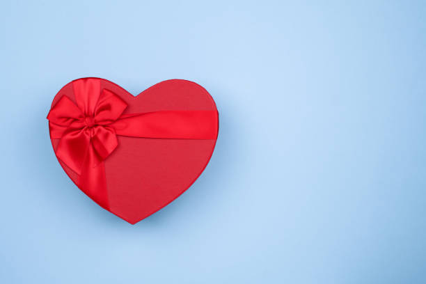 istock Red big heart-shaped gift with bow for Valentine's Day on a blue background 1300227756