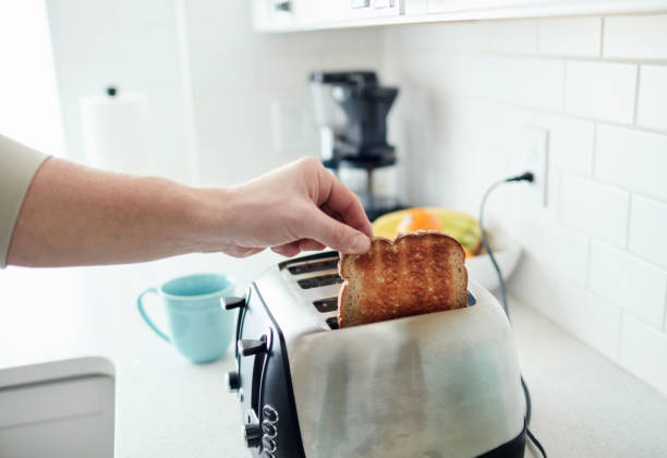 istock Unrecognizable man making toast for breakfast in brightly lit kitchen 1300229159