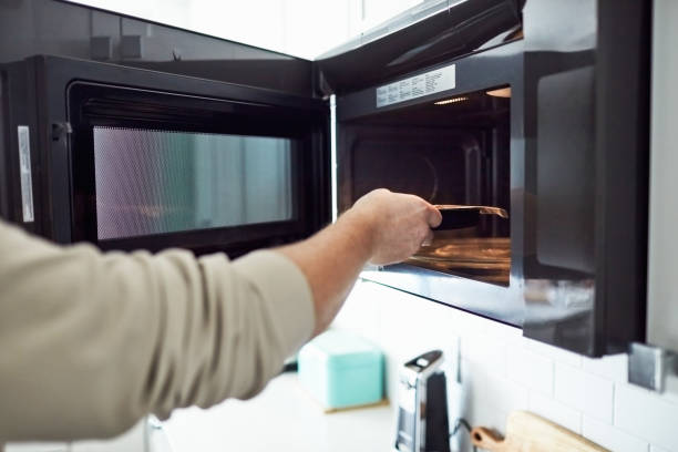 istock Unrecognizable male putting food into a microwave 1300229689