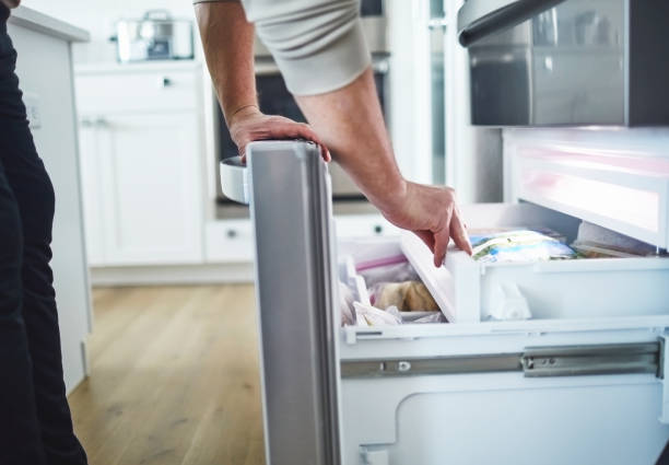Unrecognizable male searching freezer drawer for food Unrecognizable male searching freezer drawer for food freezer photos stock pictures, royalty-free photos & images