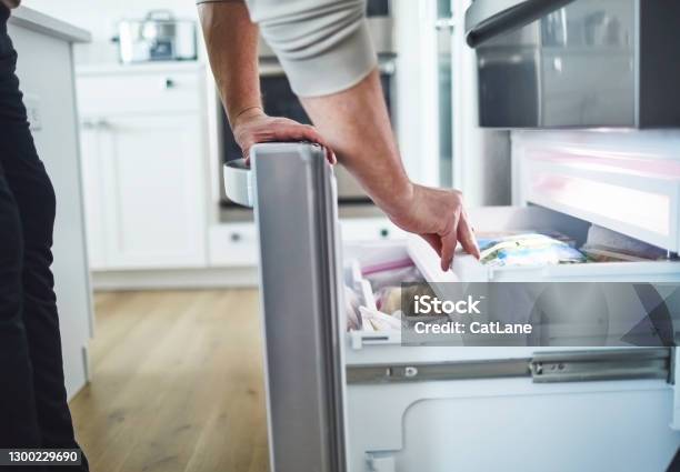 Unrecognizable Male Searching Freezer Drawer For Food Stock Photo - Download Image Now