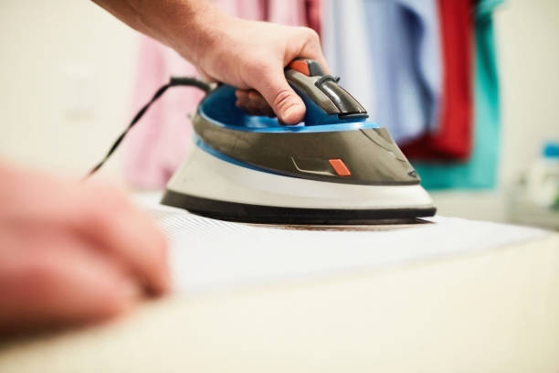 istock Unrecognizable male ironing a shirt in a home laundry room 1300229765