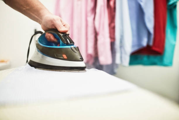 istock Unrecognizable male ironing a shirt in a home laundry room 1300229874