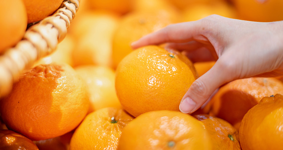 Female  hands holding the orange  for made to orange juice at the fresh market, For fruit and vegetable for good health.