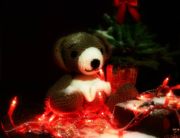 istock Christmas background. knitted bear toy, spruce with red bow and walnuts on a brown background 1300230011