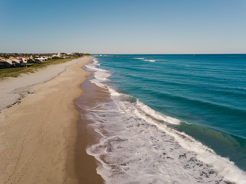 Aerial Drone Views of Teal-Colored Waves Sweeping Across the Boynton Beach, Florida Seashore on a Weekday in February 2021